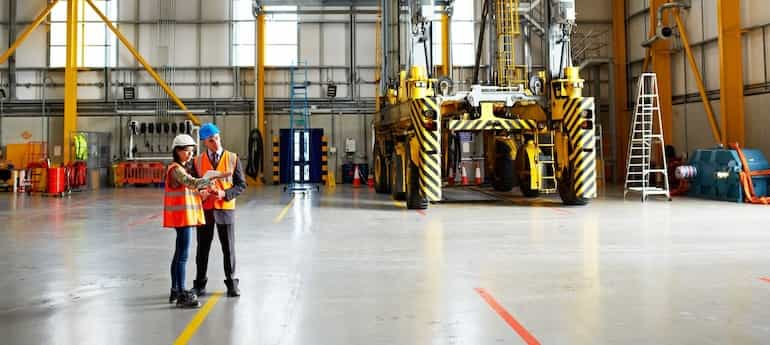 brokers review an industrial report in a warehouse